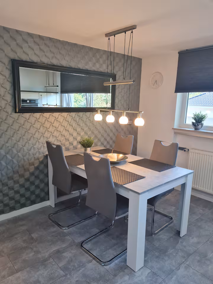 Essbereich mit Esstisch und 3D-Wandpaneel